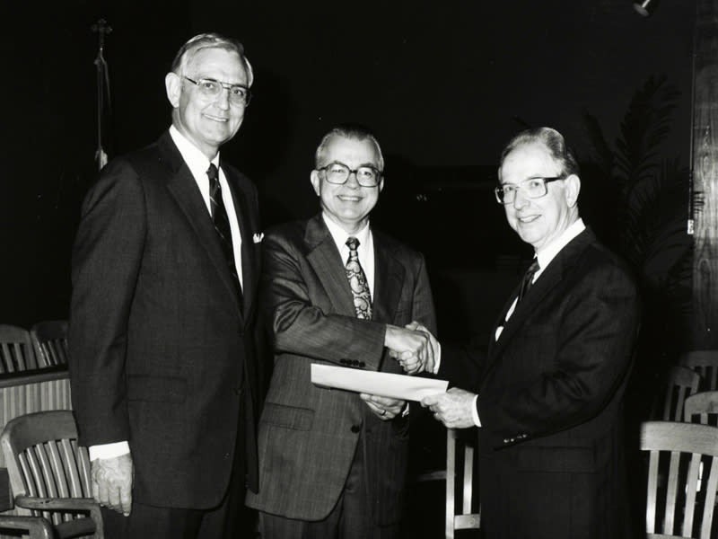 Dr. Zuck shaking hands while receiving documents